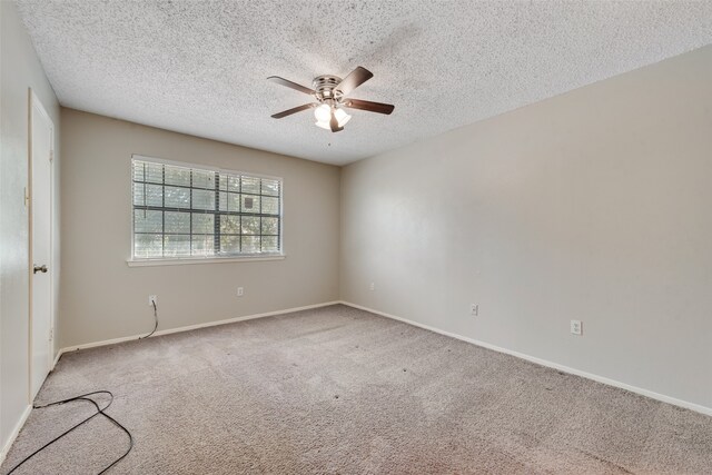 carpeted spare room featuring ceiling fan and a textured ceiling