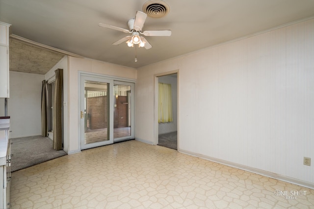 empty room featuring ceiling fan and crown molding