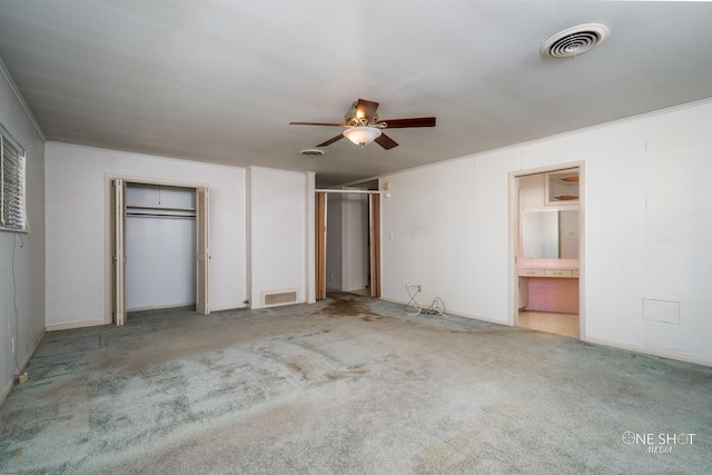 unfurnished bedroom with ceiling fan, crown molding, light colored carpet, and ensuite bathroom