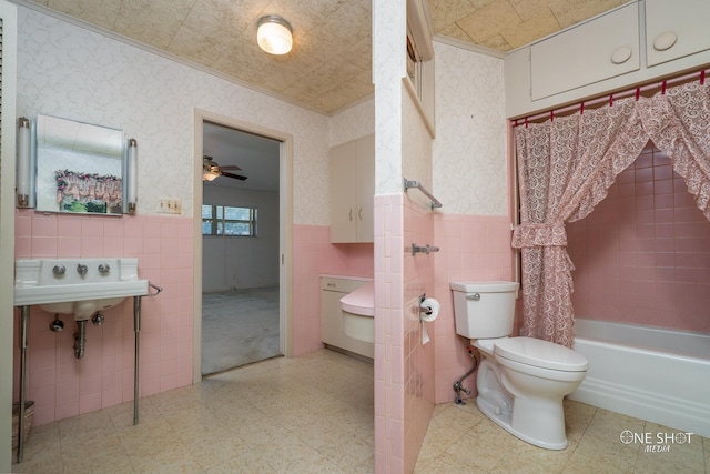 full bathroom featuring sink, ceiling fan, toilet, tile walls, and shower / tub combo with curtain