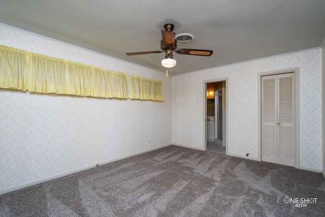 unfurnished bedroom featuring carpet flooring, ensuite bath, ceiling fan, crown molding, and a closet