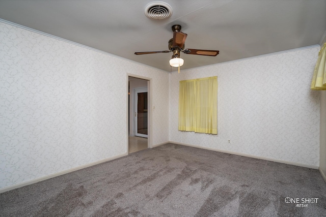 carpeted spare room with ceiling fan and ornamental molding