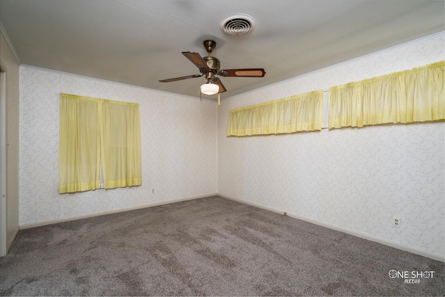 carpeted spare room with ceiling fan and ornamental molding