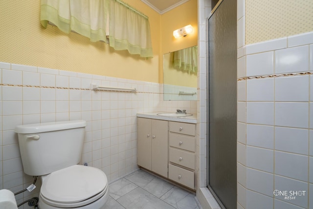 bathroom with walk in shower, crown molding, toilet, vanity, and tile walls