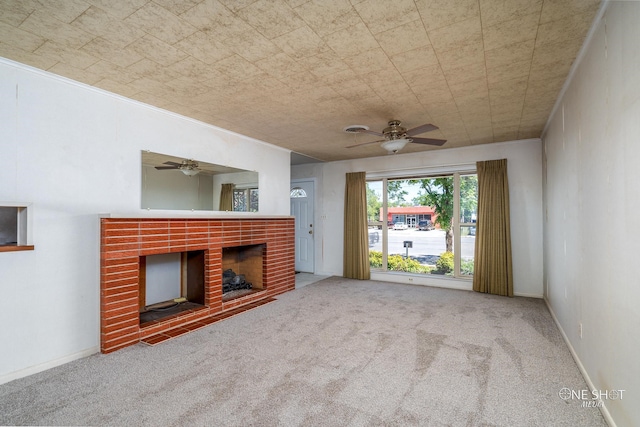 unfurnished living room with ceiling fan, carpet floors, and a brick fireplace