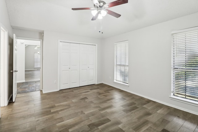 unfurnished bedroom with multiple windows and dark hardwood / wood-style flooring