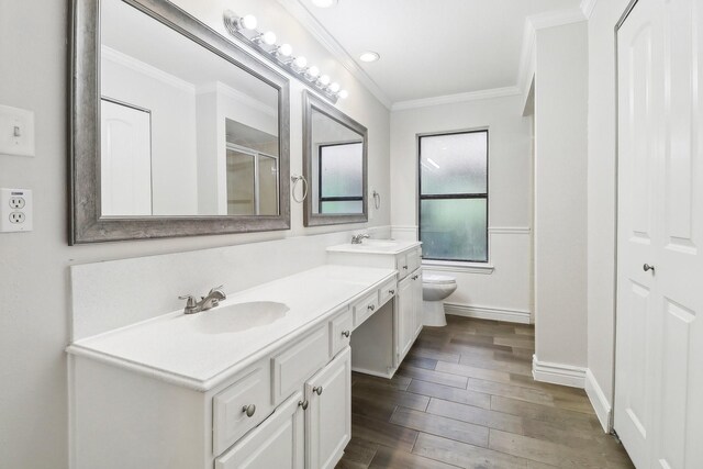 bathroom featuring toilet, a sink, ornamental molding, and wood finished floors