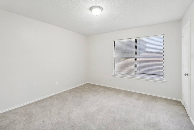 carpeted empty room with a textured ceiling