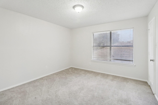 unfurnished room featuring baseboards, carpet, and a textured ceiling