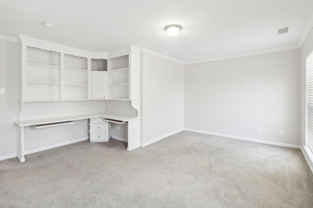 unfurnished office with built in study area, crown molding, light colored carpet, baseboards, and visible vents
