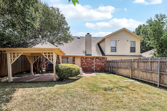 back of property with a gazebo, a yard, and a patio area