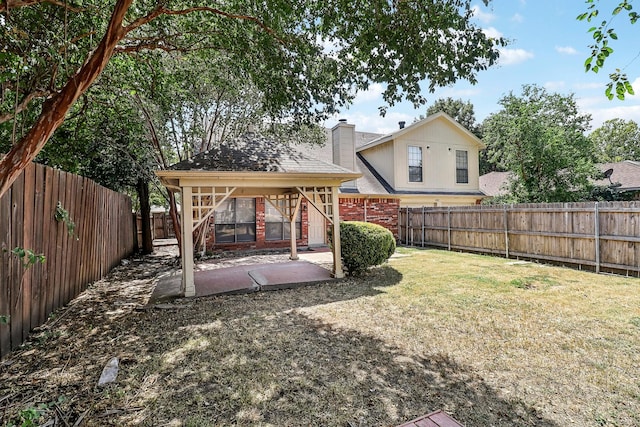 view of yard with a fenced backyard, a gazebo, and a patio area