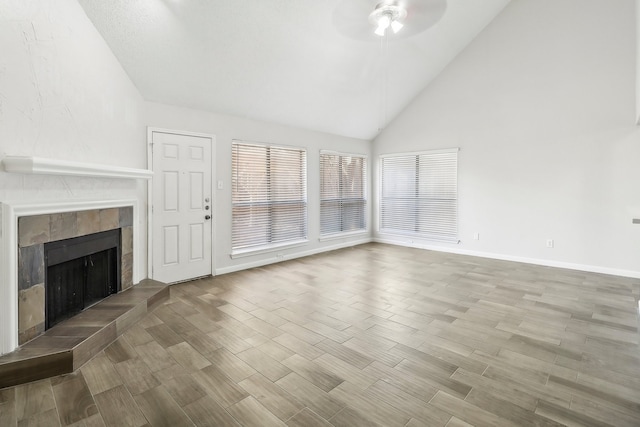 unfurnished living room featuring a fireplace, hardwood / wood-style floors, ceiling fan, and high vaulted ceiling