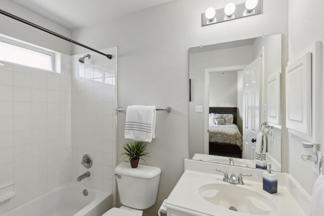 full bathroom featuring tiled shower / bath combo, vanity, and toilet