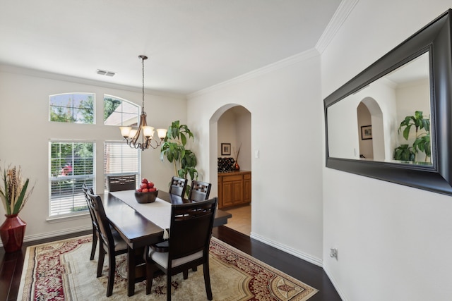 dining area with an inviting chandelier, crown molding, and hardwood / wood-style floors