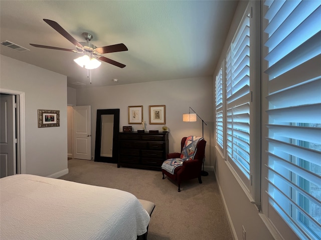 bedroom with light carpet, ceiling fan, and multiple windows