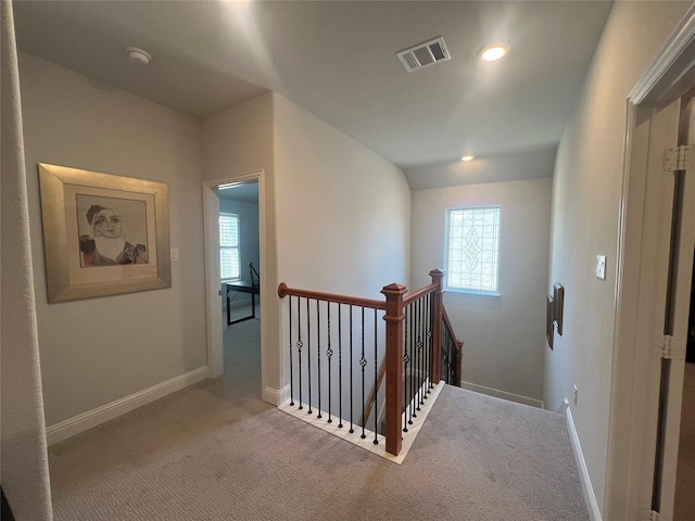 hall featuring plenty of natural light and carpet flooring