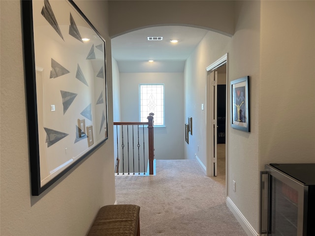 hall with light carpet and wine cooler