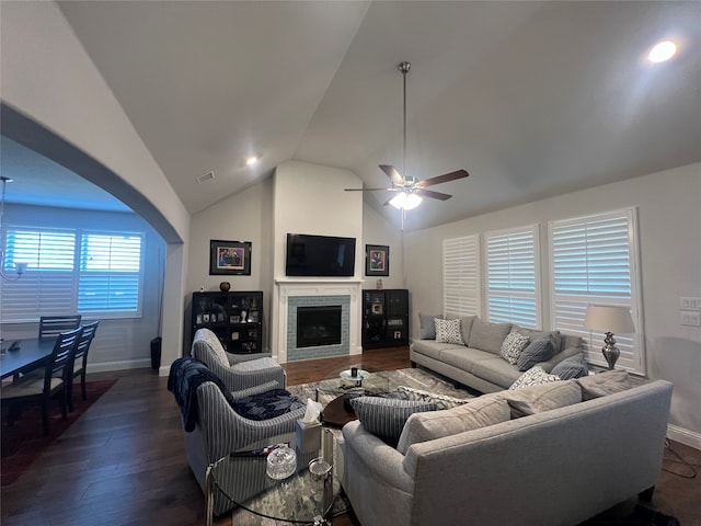 living room featuring ceiling fan, dark wood-type flooring, a brick fireplace, and vaulted ceiling