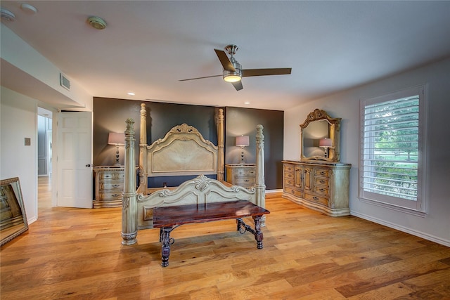 bedroom featuring ceiling fan, light wood finished floors, visible vents, and baseboards