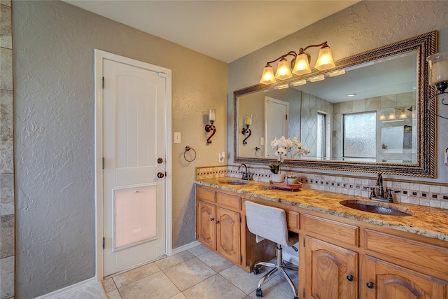 bathroom featuring a textured wall, tile patterned flooring, and a sink