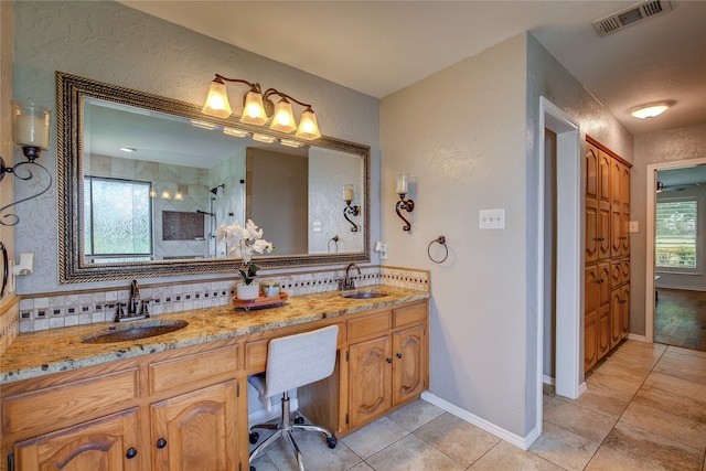 bathroom featuring vanity, tiled shower, and tile patterned flooring