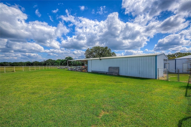 view of yard with fence, a pole building, and an outbuilding