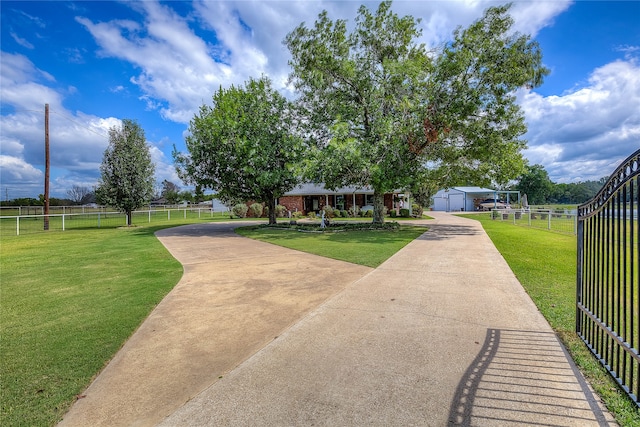 view of front of home featuring a garage, a front yard, fence, and an outbuilding