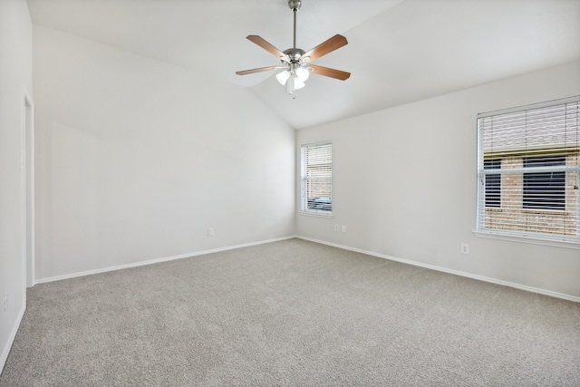 carpeted spare room featuring vaulted ceiling, ceiling fan, and plenty of natural light