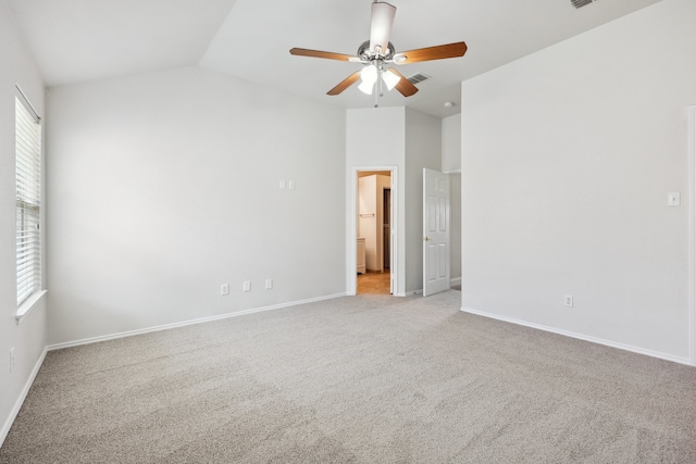 unfurnished bedroom with lofted ceiling, multiple windows, light colored carpet, and ceiling fan