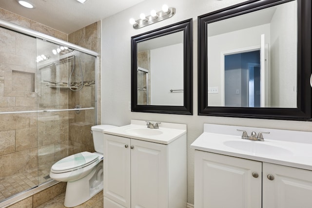 bathroom featuring vanity, toilet, a shower with door, and tile patterned floors