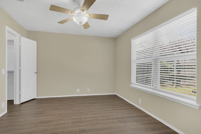 unfurnished room featuring a textured ceiling, dark hardwood / wood-style flooring, and ceiling fan