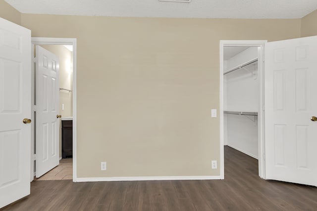 4629 Grant Park Ave, Fort Worth, TX 76137 - unfurnished bedroom featuring dark wood-style floors, a closet, baseboards, and a spacious closet