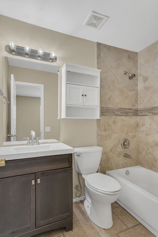 full bathroom featuring tiled shower / bath combo, vanity, toilet, and tile patterned floors