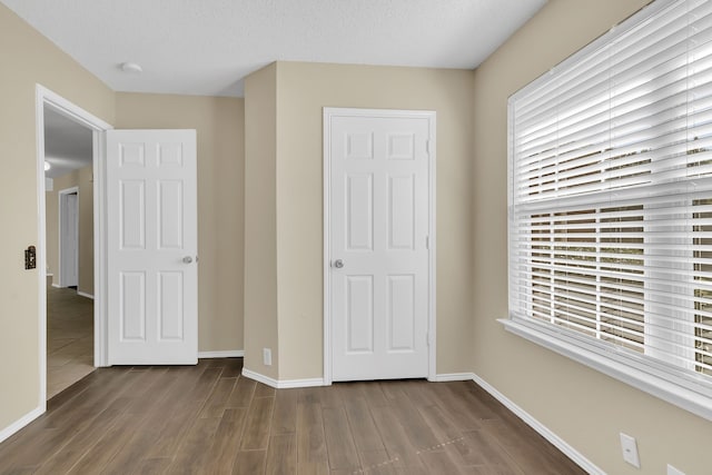 4629 Grant Park Ave, Fort Worth, TX 76137 - unfurnished bedroom with dark wood-type flooring, a textured ceiling, and baseboards