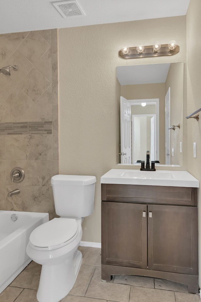 full bathroom with tiled shower / bath, vanity, toilet, and tile patterned floors