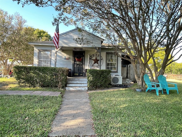 view of front of property with ac unit and a front lawn