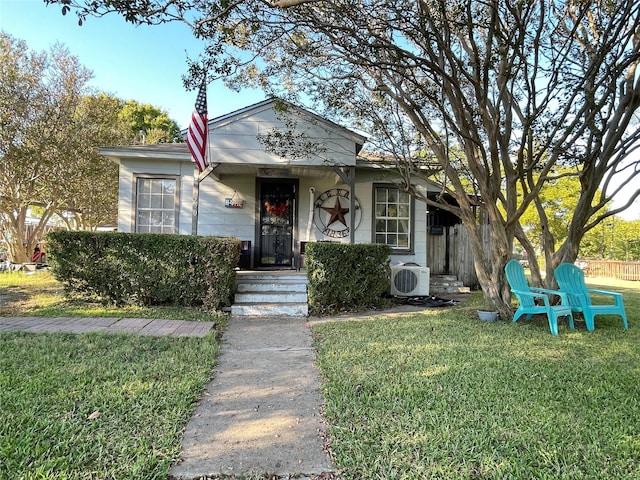 view of front of property with ac unit and a front yard