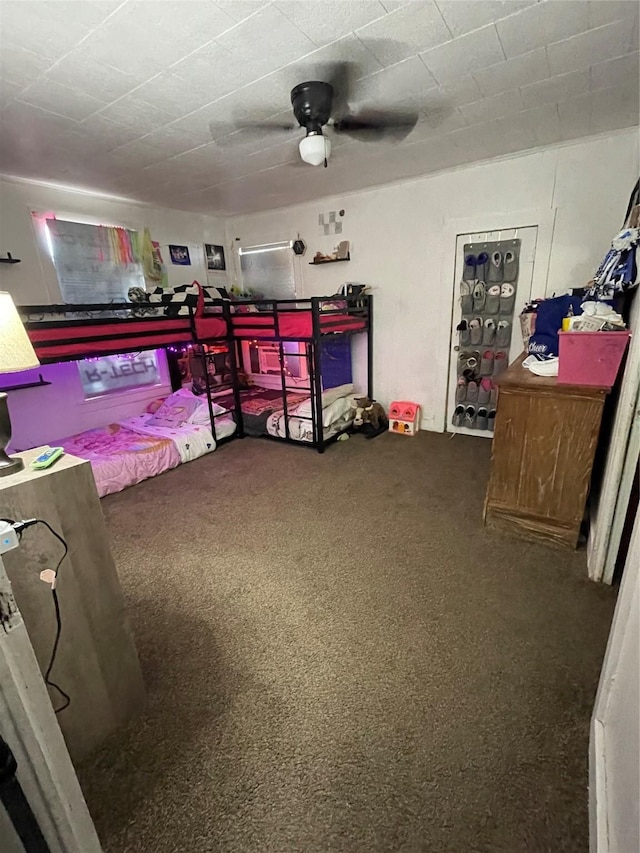 bedroom with ceiling fan and dark colored carpet