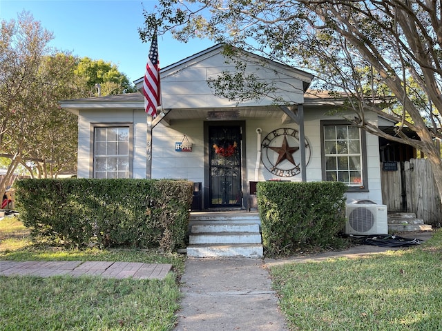 view of front facade with a front yard and ac unit