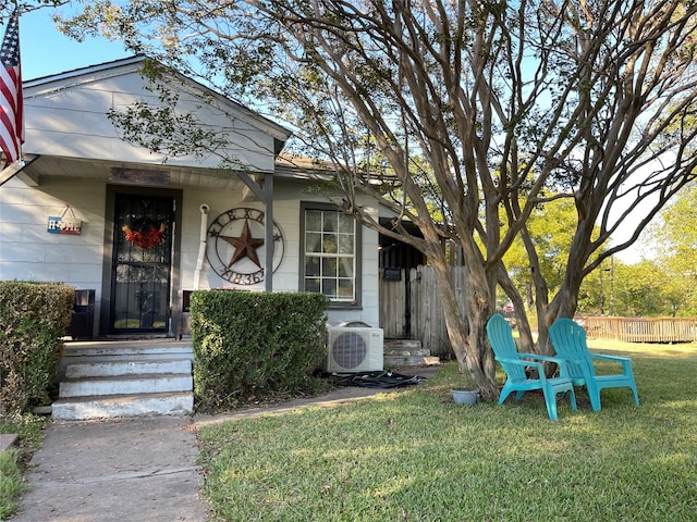 doorway to property featuring ac unit and a lawn