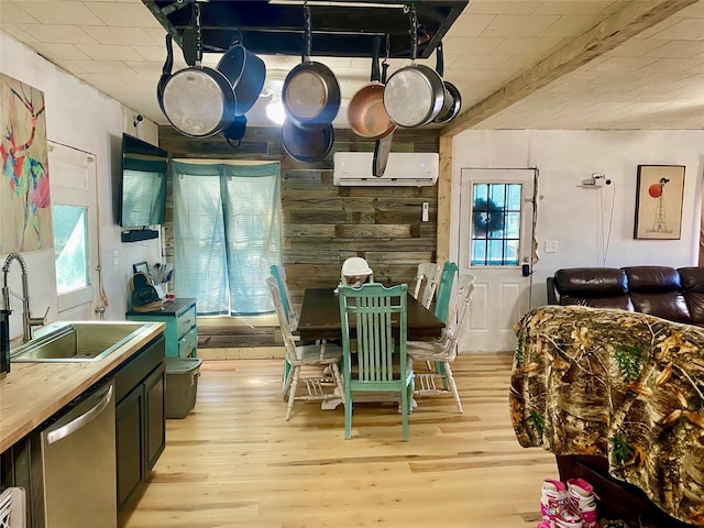 kitchen with sink, light hardwood / wood-style flooring, wooden counters, dishwasher, and a wall mounted air conditioner