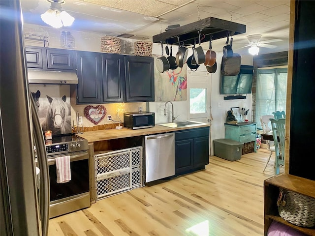 kitchen with butcher block counters, sink, light hardwood / wood-style flooring, ceiling fan, and stainless steel appliances