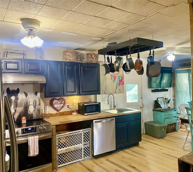 kitchen with sink, light wood-type flooring, stainless steel appliances, and blue cabinetry