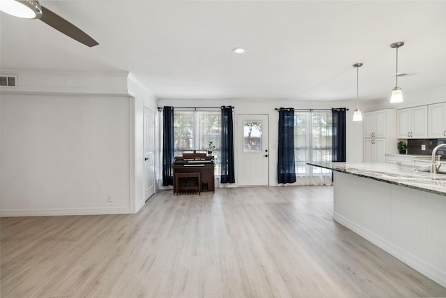 empty room with ceiling fan, crown molding, and light hardwood / wood-style floors