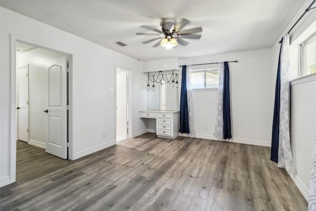 unfurnished bedroom with hardwood / wood-style flooring, ceiling fan, and a textured ceiling