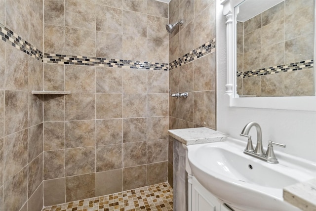 bathroom featuring a tile shower and vanity