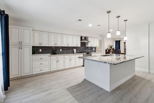 kitchen featuring light wood-type flooring, tasteful backsplash, sink, wall chimney range hood, and white cabinets