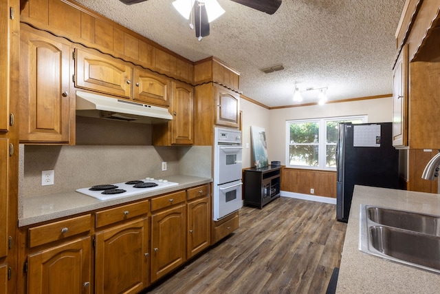 kitchen with dark wood-type flooring, white appliances, crown molding, ceiling fan, and sink