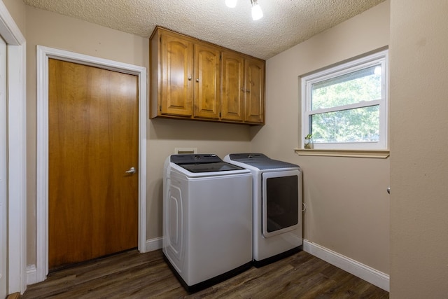 laundry room featuring cabinets, dark hardwood / wood-style floors, washer and dryer, and a textured ceiling